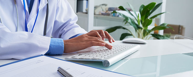 Photo of doctor typing on keyboard